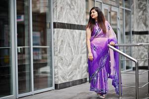 indisk hinduisk flicka på traditionella violetta saree poserade på gatan. foto