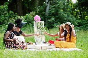 grupp afroamerikanska flickor som firar födelsedagsfest utomhus med inredning. foto