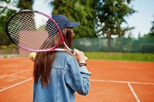 ung sportig tjejspelare med tennisracket på tennisbanan. foto