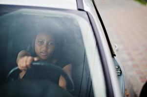 porträtt av ung afroamerikansk kvinna som kör bil. foto