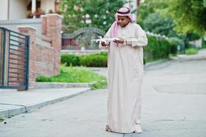 mellanöstern arabisk affärsman poserade på gatan med drönare eller quadcopter vid händerna. foto