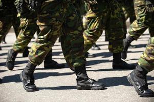 militär marscherar på en gata. ben och skor i linje foto