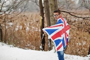 snygg indisk man i kostym med Storbritannien flagga poserade på vinterdag utomhus. foto