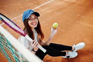 ung sportig tjejspelare med tennisracket på tennisbanan. foto