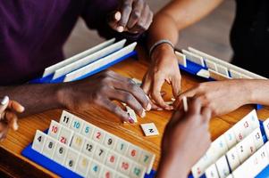 grupp på tre afroamerikanska vänner spelar bordsspel. foto