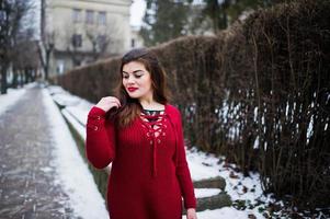 brunett plus size modell på rött på gatan i staden. foto