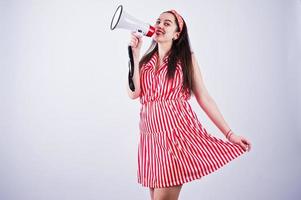 porträtt av en ung vacker kvinna i röd klänning som pratar i megafon. foto