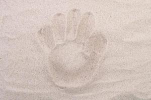 palm fotavtryck i sanden ovanifrån. sand kopia utrymme. sand bakgrund ovanifrån. foto