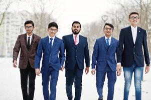 grupp av fem indisk affärsman i kostym poserade och gå utomhus i vinterdag i Europa. foto