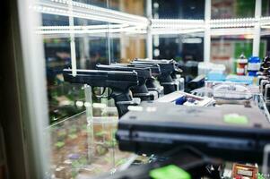 olika vapen och revolvrar på hyllorna lagrar vapen på butikscentret. foto