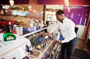 afroamerikansk bartender i baren med ishink. beredning av alkoholhaltiga drycker. foto