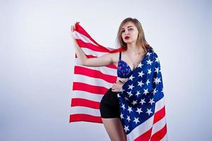 söt flicka i bh och shorts med amerikanska flaggan isolerad på vit bakgrund. foto