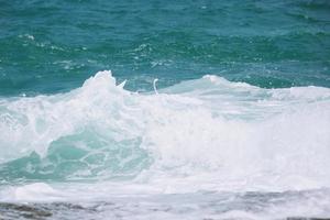 havsvågor i havet våg stänk krusning vatten. blått vatten bakgrund. foto