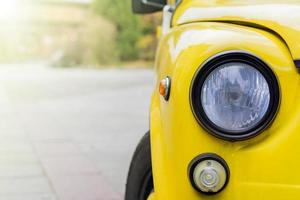närbild av gul retro bil med runda strålkastare. foto