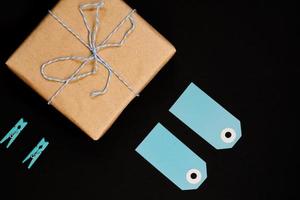 handgjorda presentförpackningar inslagna i hantverkspapper med blå papperskortetikett, rep och klädnypor av trä för dekoration. foto