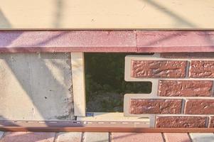 en arbetare installerar paneler brun sidospår på fasaden av huset foto