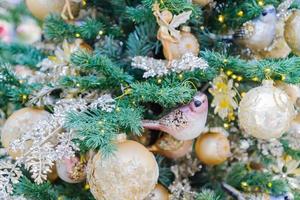jul och nyår semester bakgrund. julgran dekorerade guldgranskulor och girlanger. glittrande och gnistrande. firande koncept foto