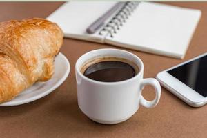 kaffepaus med croissant och espress. frilansare på jobbet. foto