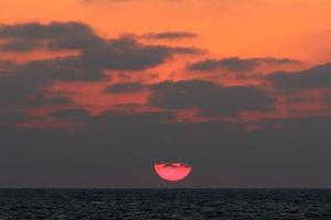 solen går ner under horisonten på Medelhavet i norra Israel. foto