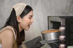 ung vacker kvinna bakar i sitt kök, bageri och kaféverksamhet foto