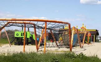 modern offentlig lekplats mot de blå himmel. en färgrik spela och sporter komplex för barn utan människor. Utrustning för sten klättrande och överfall på de lekplats. foto