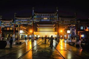 Peking, Kina - 24 februari 2017 obekant kinesisk människor eller turist gående i kväll tid på zhengyang Port jianlou qianmen gata de känd gata i beijing huvudstad stad av Kina foto