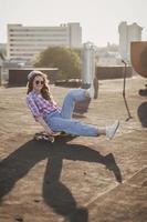 ung hipster flicka med skateboard. semester stil, ljus färger. foto