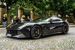 Tyskland, fulda - juli 2019 mörk grå ferrari f12 berlinetta kupé också inofficiellt hänvisade till som de f12 berlinetta eller de f12, och inofficiellt stiliserade som de f12b för kort typ f152 är en främre mi foto