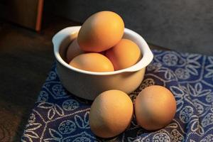 ägg i skål på träbord för matinnehåll. foto