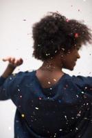 afrikansk amerikan kvinna blåser konfetti i de luft foto