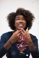 afrikansk amerikan kvinna blåser konfetti i de luft foto