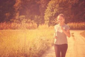 kvinna joggar längs en landsväg foto