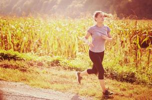 kvinna joggar längs en landsväg foto