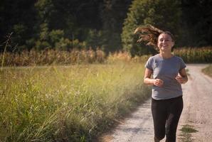 kvinna joggar längs en landsväg foto