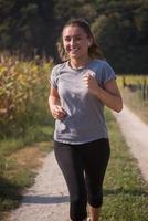 kvinna joggar längs en landsväg foto