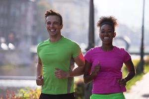 ung multietnisk par joggning i de stad foto