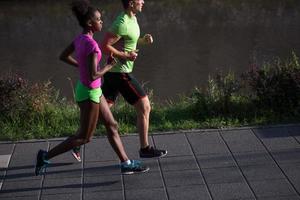 ung leende multietnisk par joggning i de stad foto