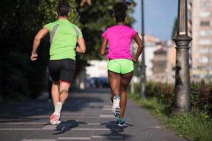 ung leende multietnisk par joggning i de stad foto