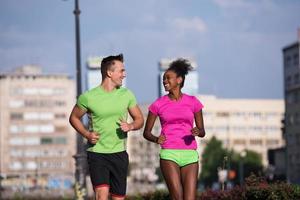 ung leende multietnisk par joggning i de stad foto