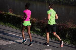 ung leende multietnisk par joggning i de stad foto