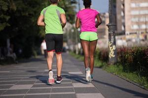 ung leende multietnisk par joggning i de stad foto