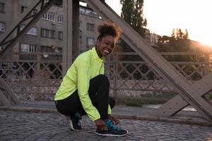 afrikansk amerikan kvinna löpare åtdragning sko spets foto