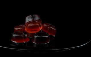 mycket skön marmelad godis på en svart tallrik på en svart bakgrund. foto