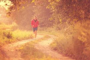 man joggar längs en landsväg foto