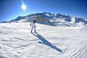 skidåkning på nysnö på vintersäsongen på vacker solig dag foto