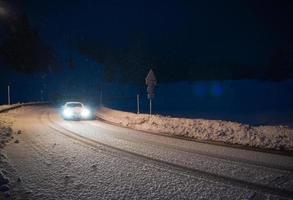 bil körning på farlig väg på natt på snö foto