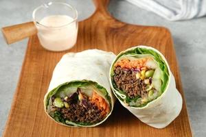 sallad slå in. tortilla wraps med nötkött teriyaki och färsk grönsaker. foto