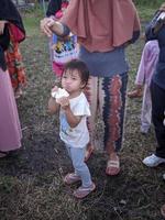 de spänning av vuxna och barn tar del i en kracker äter konkurrens till liva upp de oberoende dag av de republik av Indonesien, öst kalimantan, indonesien augusti 13, 2022 foto