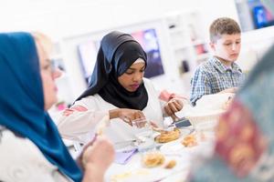 svart modern muslim kvinna njuter iftar middag med familj foto