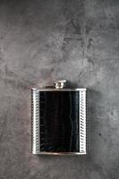 stål flaska i läder Avsluta för alkohol på en mörk bakgrund med kopia Plats foto